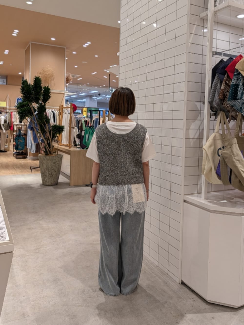 ホワイト系のTシャツ/カットソー、グレー系のベスト、ブルー系のデニムパンツを着用したレディースの夏コーディネートの3枚目の写真