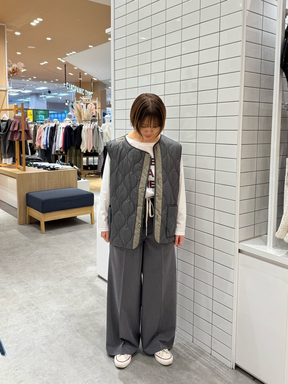 グリーン系のモッズコート、ホワイト系のTシャツ/カットソー、グレー系のパンツを着用したレディースの春コーディネートの4枚目の写真
