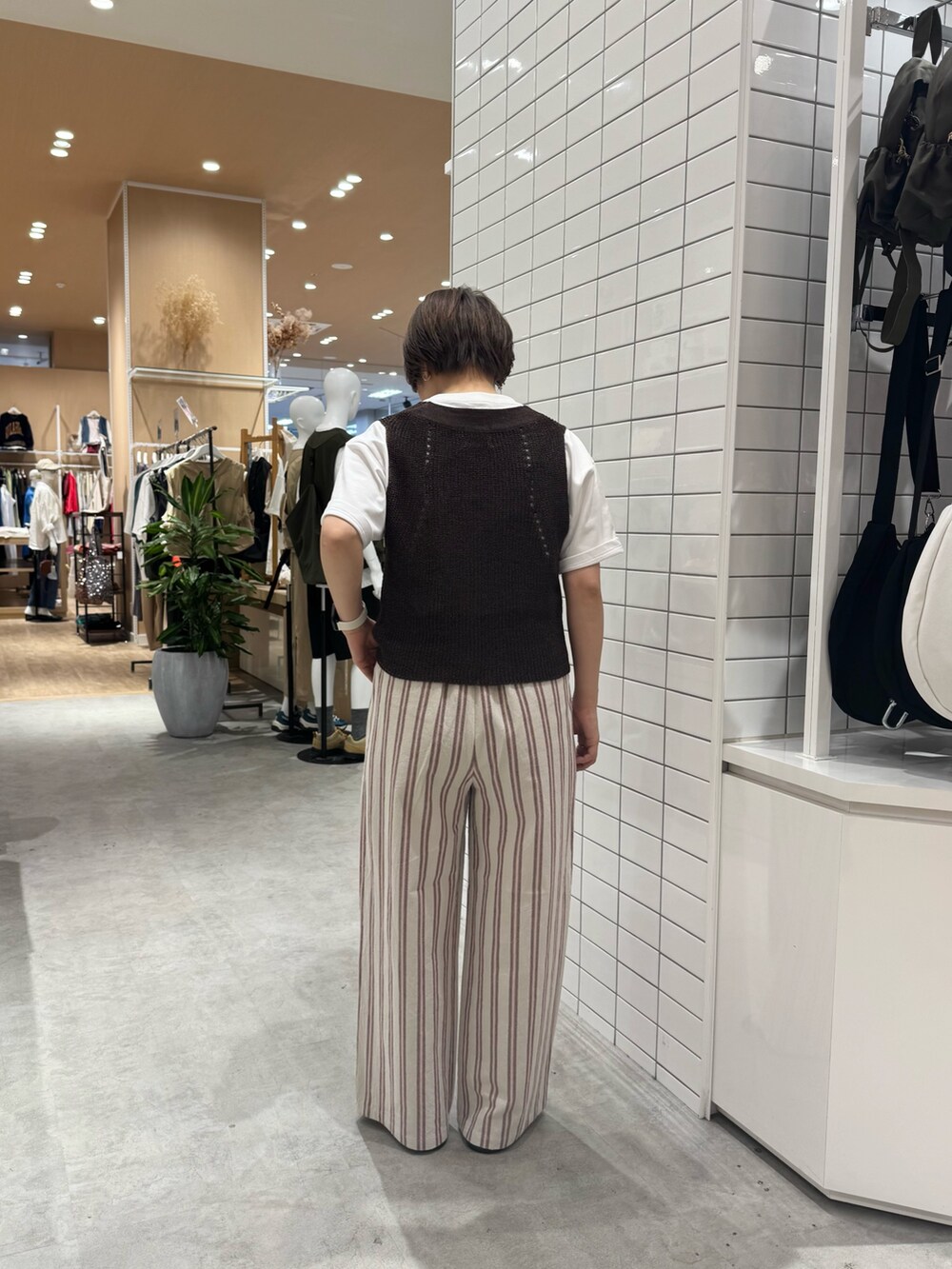 ブラウン系のベスト、ホワイト系のその他パンツ、ホワイト系のTシャツ/カットソーを着用したレディースの夏コーディネートの4枚目の写真