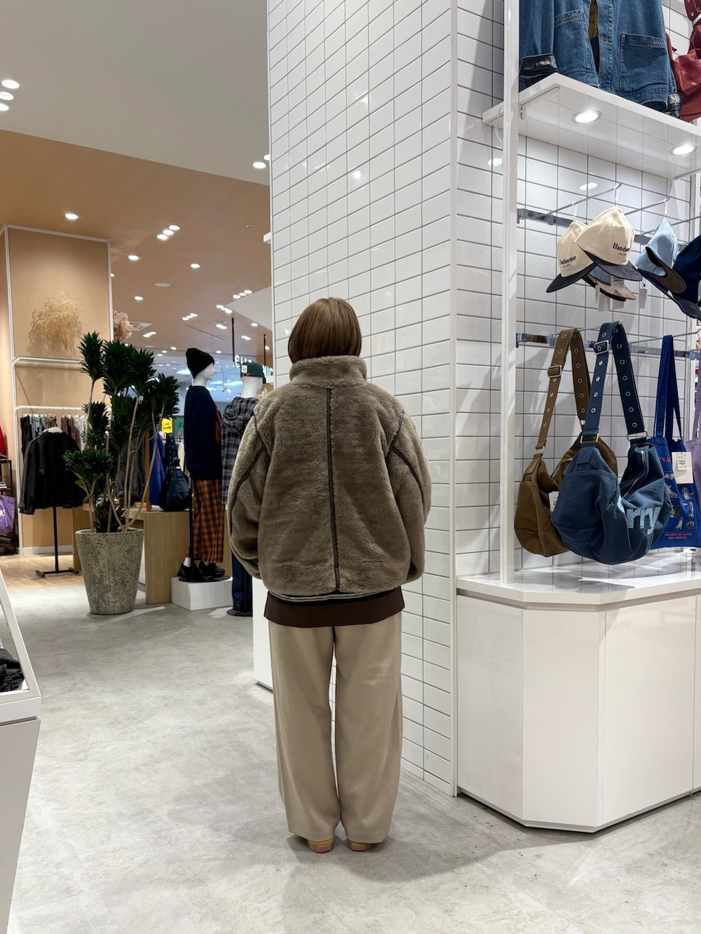 ベージュ系のスラックス、ブラウン系のTシャツ/カットソー、ベージュ系のブルゾンを着用したレディースの秋コーディネートの4枚目の写真