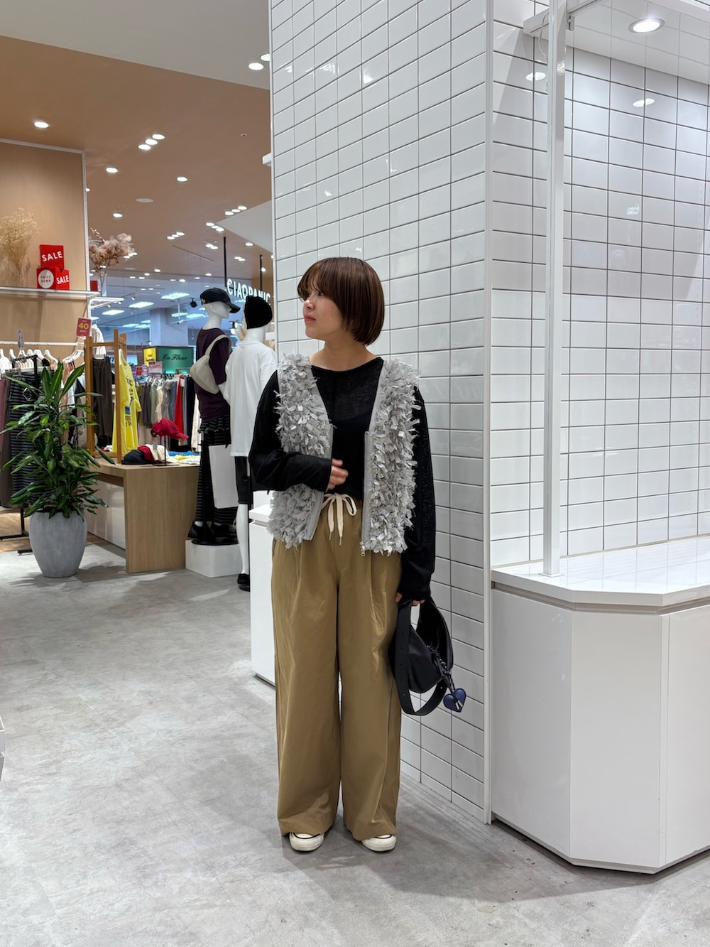 ブラック系のTシャツ/カットソー、グレー系のベスト、ベージュ系のデニムパンツを着用したレディースの秋コーディネートの3枚目の写真