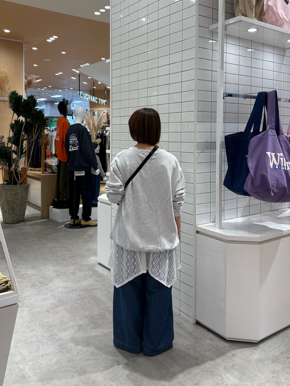 ブルー系のデニムパンツ、ピンク系のボディバッグ/ウエストポーチ、ホワイト系のタンクトップを着用したレディースの秋コーディネートの4枚目の写真