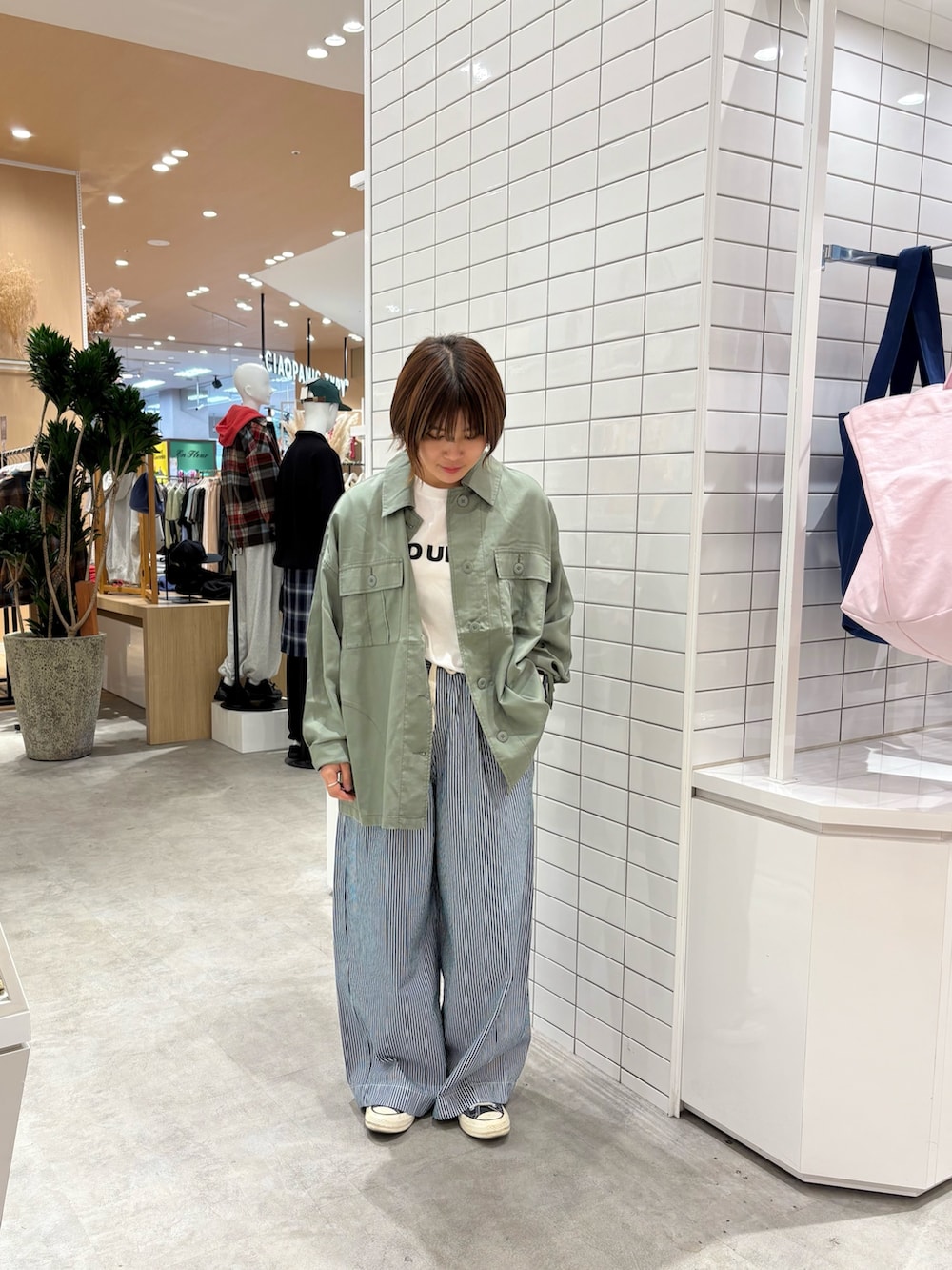 ブルー系のデニムパンツ、ホワイト系のTシャツ/カットソー、グリーン系のシャツ/ブラウスを着用したレディースの秋コーディネートの3枚目の写真