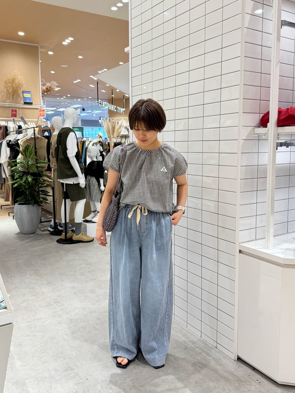 ブラック系のシャツ/ブラウス、ブルー系のデニムパンツ、ブラック系のサンダルを着用したレディースの夏コーディネートの2枚目の写真