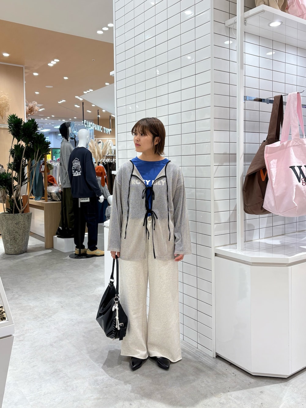 ホワイト系のスウェットパンツ、ブラック系のトートバッグ、ブルー系のTシャツ/カットソーを着用したレディースの秋コーディネートの3枚目の写真