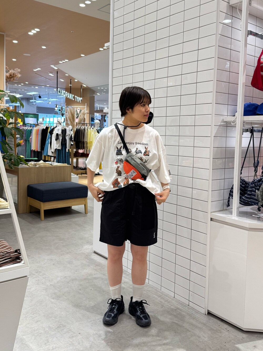 グレー系のトートバッグ、ホワイト系のTシャツ/カットソー、ブラック系のその他パンツを着用したレディースの春コーディネートの3枚目の写真