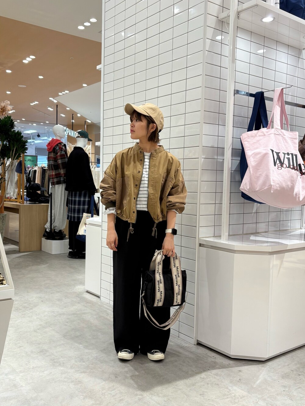 イエロー系のブルゾン、グレー系のTシャツ/カットソー、ブラック系のショルダーバッグを着用したレディースの秋コーディネートの3枚目の写真