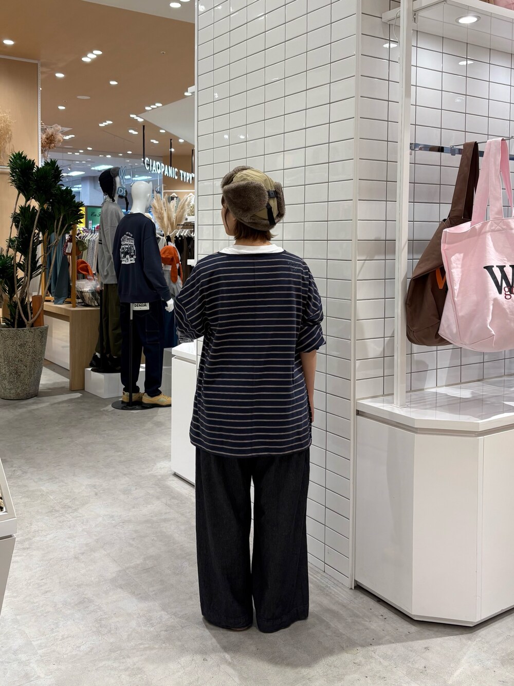 ブルー系のTシャツ/カットソー、ブラック系のデニムパンツ、ベージュ系のハットを着用したレディースの秋コーディネートの4枚目の写真