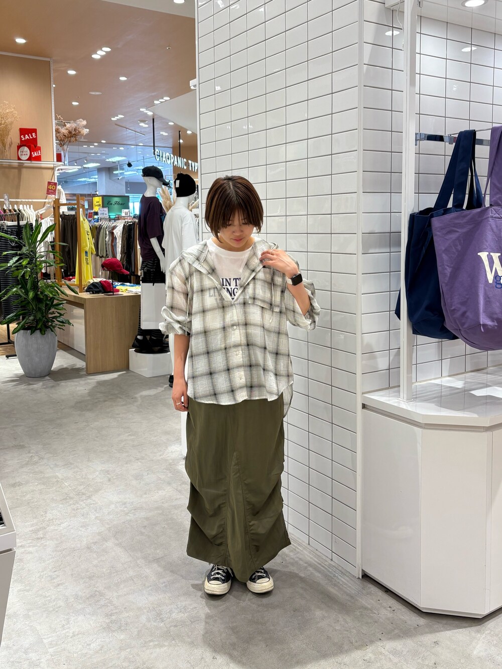 グリーン系のスカート、ホワイト系のシャツ/ブラウス、ホワイト系のTシャツ/カットソーを着用したレディースの秋コーディネートの3枚目の写真