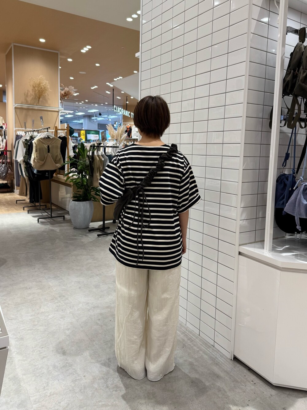 グレー系のトートバッグ、ブラック系のTシャツ/カットソー、ホワイト系のその他パンツを着用したレディースの夏コーディネートの3枚目の写真