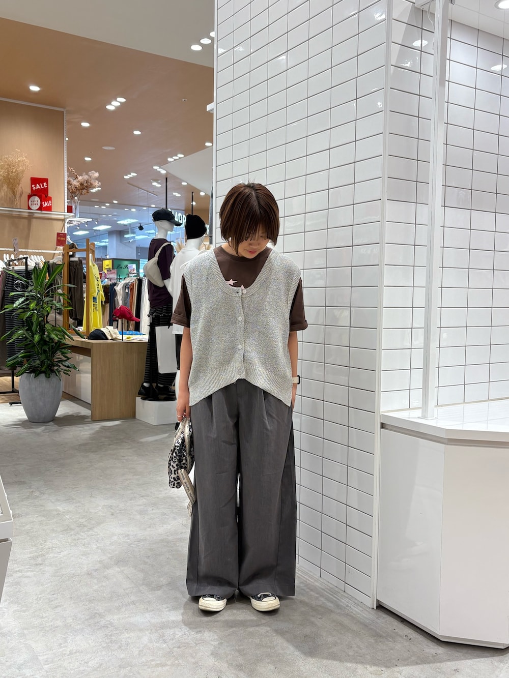 ブラウン系のTシャツ/カットソー、ホワイト系のベスト、ホワイト系のショルダーバッグを着用したレディースの秋コーディネートの3枚目の写真