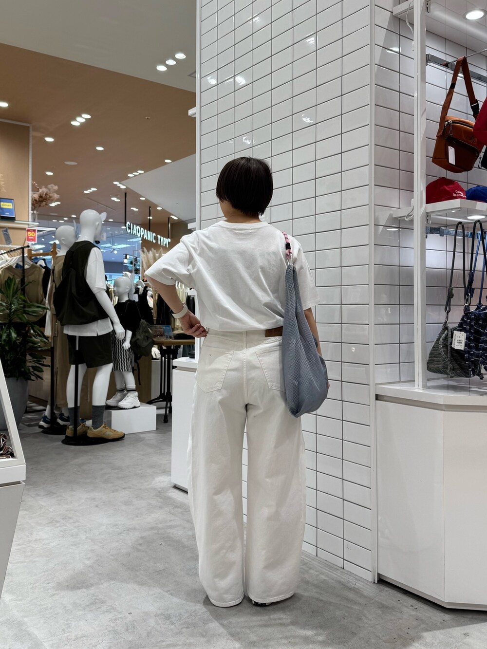 ホワイト系のTシャツ/カットソー、ホワイト系のデニムパンツ、グレー系のトートバッグを着用したレディースの春コーディネートの4枚目の写真