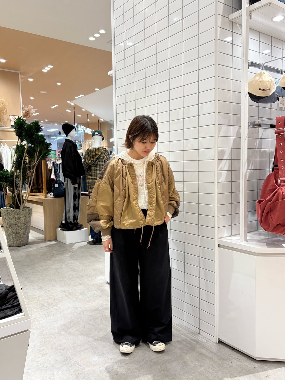 ブラック系のデニムパンツ、イエロー系のブルゾン、ホワイト系のTシャツ/カットソーを着用したレディースの秋コーディネートの2枚目の写真