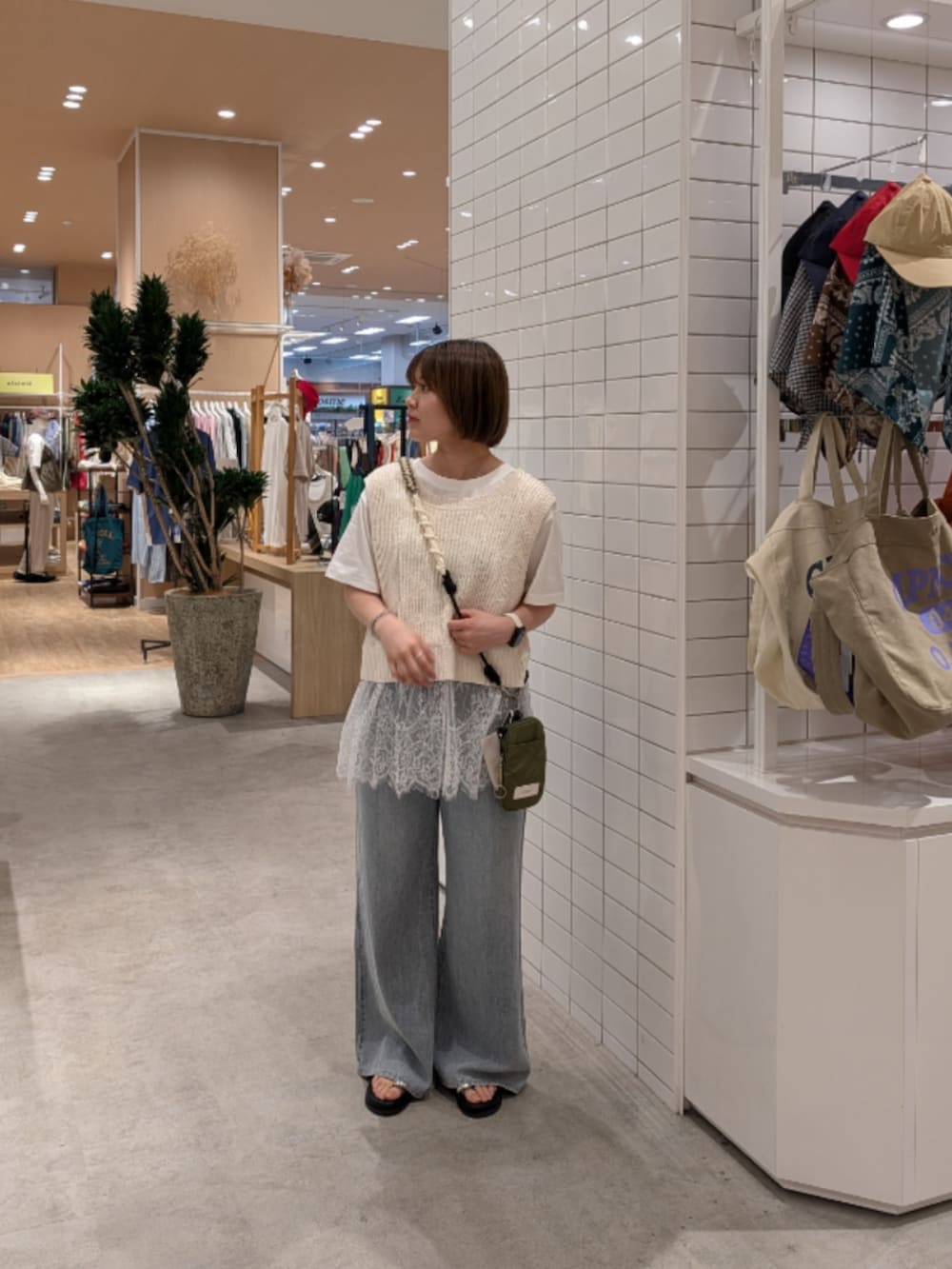 ホワイト系のベスト、ホワイト系のTシャツ/カットソー、ブルー系のデニムパンツを着用したレディースの夏コーディネートの2枚目の写真