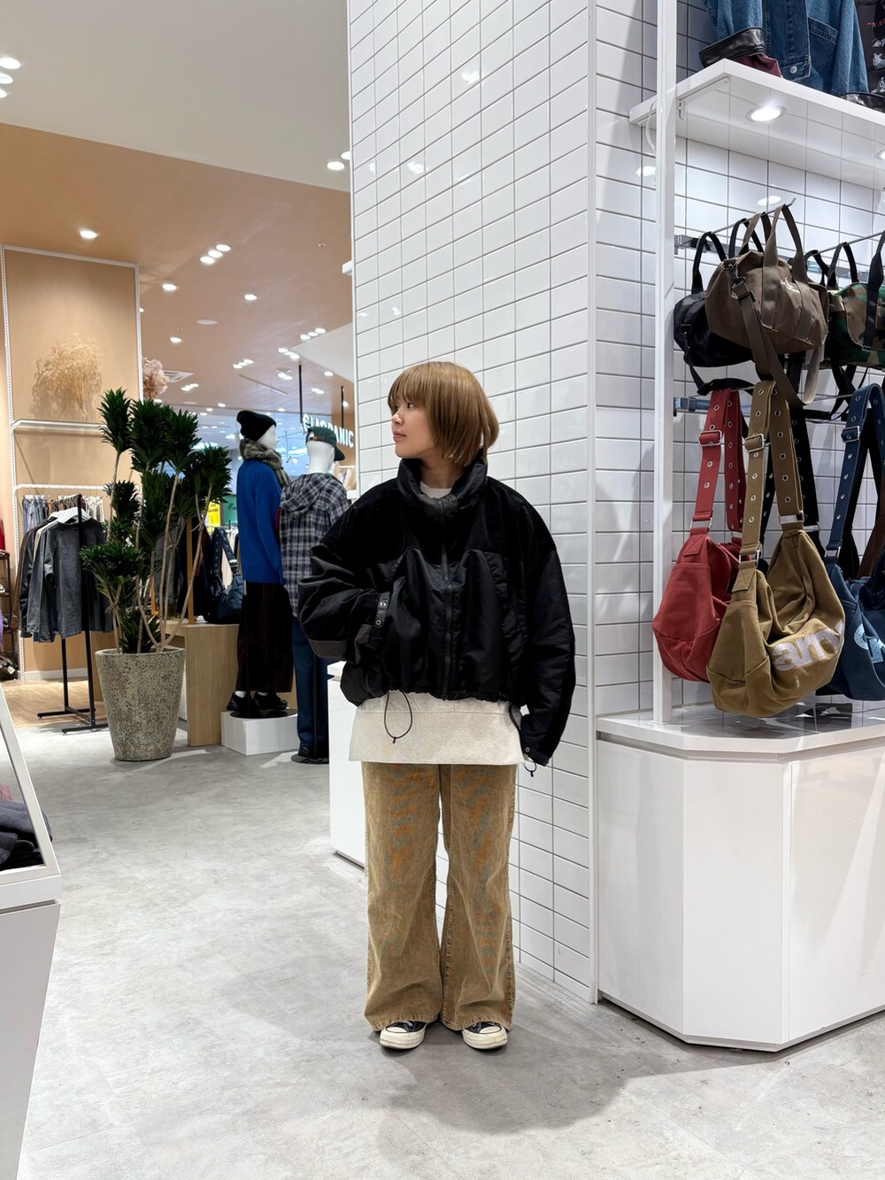 ブラック系のダウンジャケット/コート、ホワイト系のスウェット、イエロー系のデニムパンツを着用したレディースの秋コーディネートの3枚目の写真