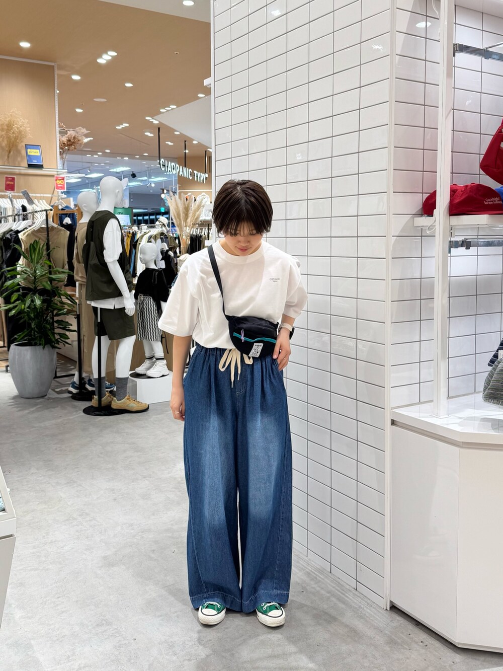 ブラック系のトートバッグ、ホワイト系のTシャツ/カットソー、ブルー系のデニムパンツを着用したレディースの春コーディネートの2枚目の写真