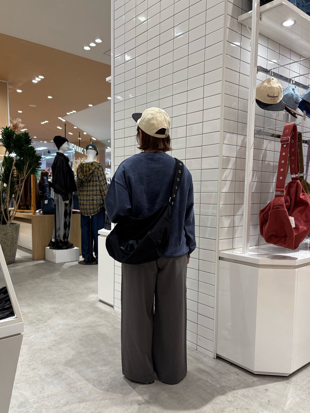 グレー系のデニムパンツ、ブルー系のスウェット、ブラック系のトートバッグを着用したレディースの秋コーディネートの4枚目の写真