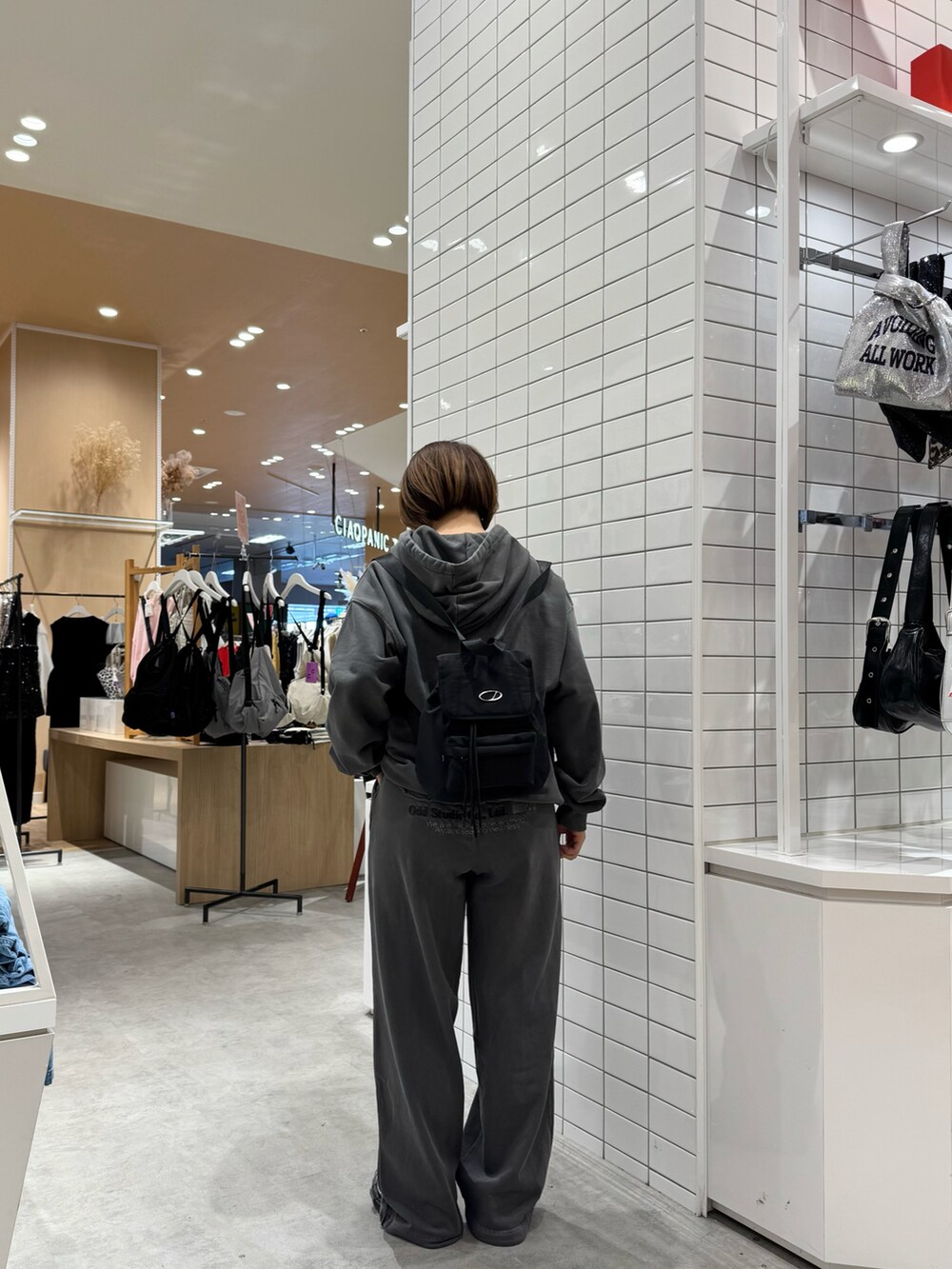 グレー系のその他パンツ、グレー系のパーカー、ブラック系のバックパック/リュックを着用したレディースの春コーディネートの3枚目の写真