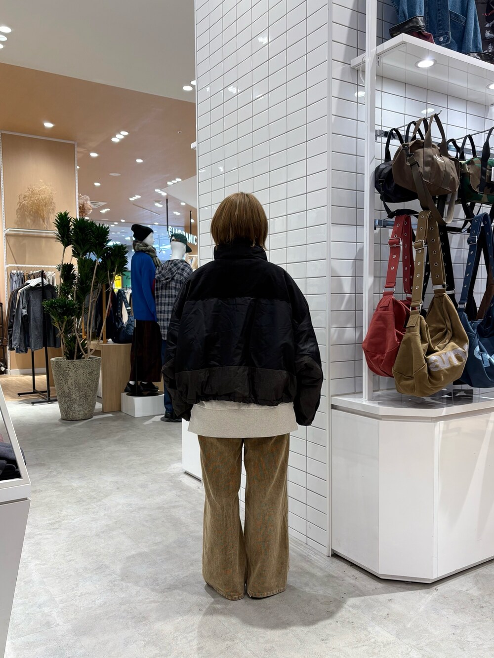 ブラック系のダウンジャケット/コート、ホワイト系のスウェット、イエロー系のデニムパンツを着用したレディースの秋コーディネートの5枚目の写真