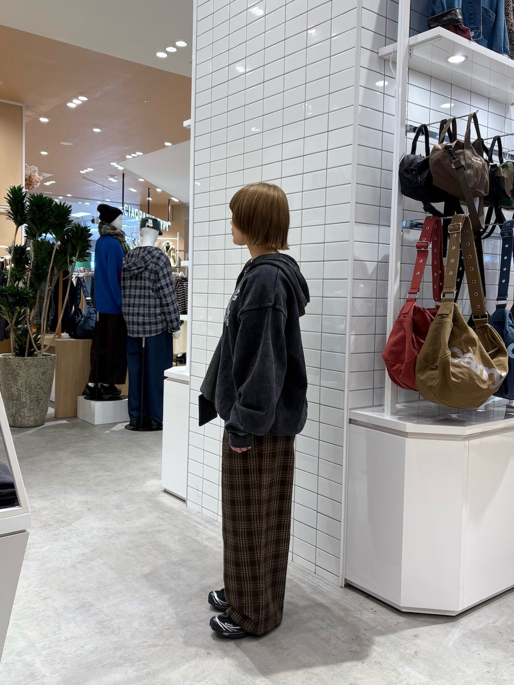 ブラック系のパーカー、ブラウン系のその他パンツ、グレー系のトートバッグを着用したレディースの秋コーディネートの4枚目の写真