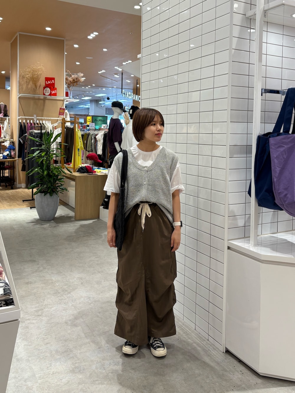 ブラウン系のスカート、ホワイト系のベスト、ホワイト系のTシャツ/カットソーを着用したレディースの秋コーディネートの3枚目の写真