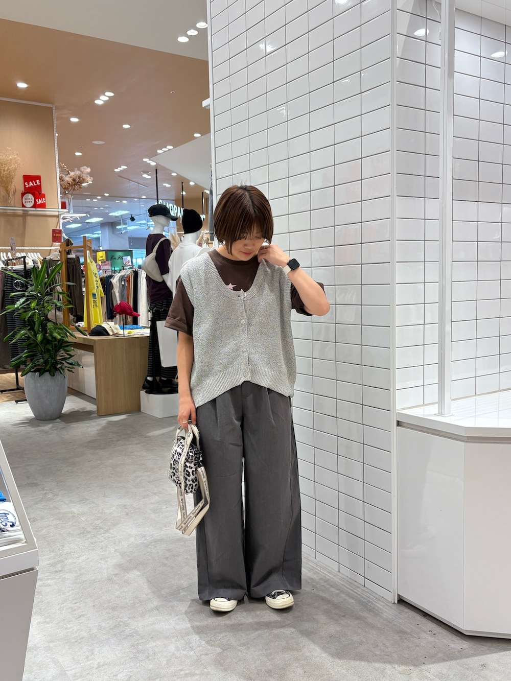 ブラウン系のTシャツ/カットソー、ホワイト系のベスト、ホワイト系のショルダーバッグを着用したレディースの秋コーディネートの2枚目の写真