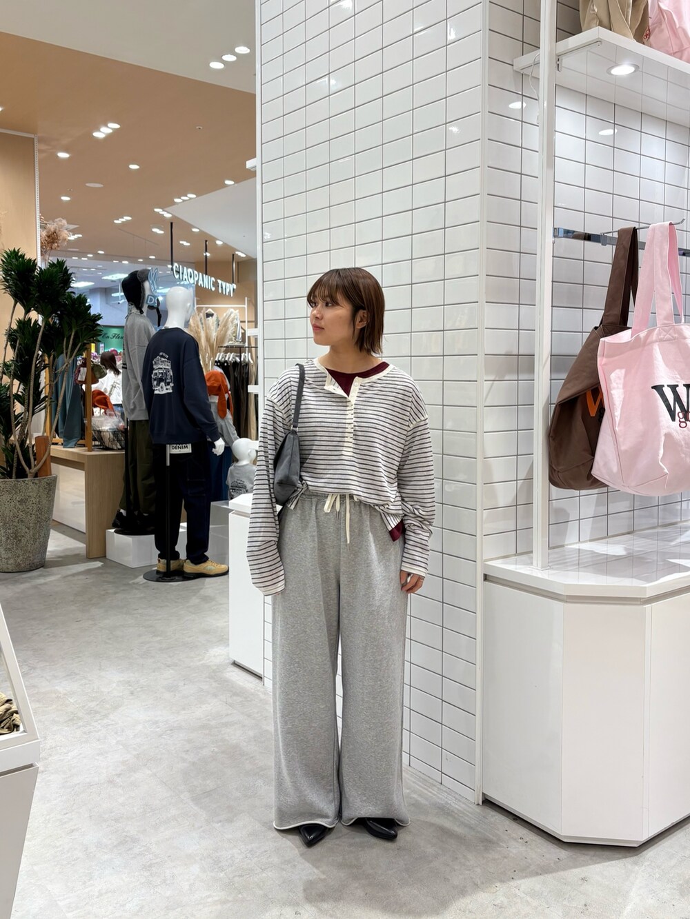 グレー系のスウェットパンツ、ブラック系のパンプス、グレー系のハンドバッグを着用したレディースの秋コーディネートの3枚目の写真