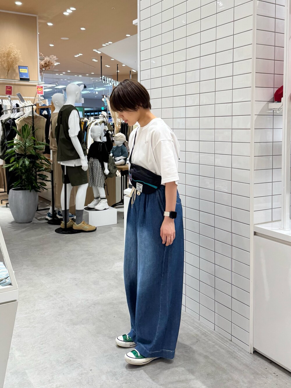 ブラック系のトートバッグ、ホワイト系のTシャツ/カットソー、ブルー系のデニムパンツを着用したレディースの春コーディネートの3枚目の写真