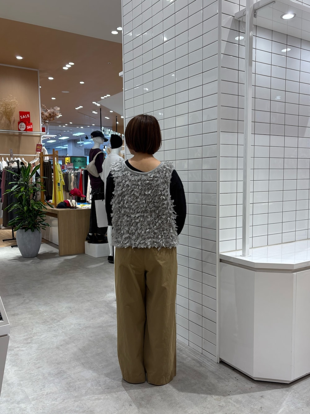 ブラック系のTシャツ/カットソー、グレー系のベスト、ベージュ系のデニムパンツを着用したレディースの秋コーディネートの5枚目の写真