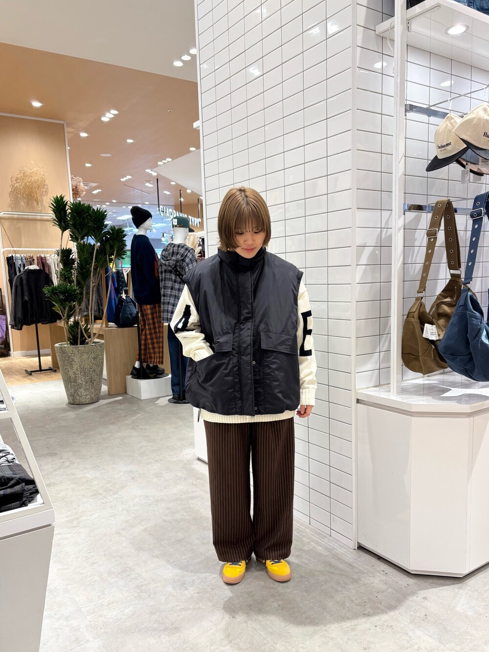 ホワイト系のニット/セーター、ブラウン系のスラックス、ブラック系のブルゾンを着用したレディースの秋コーディネートの3枚目の写真