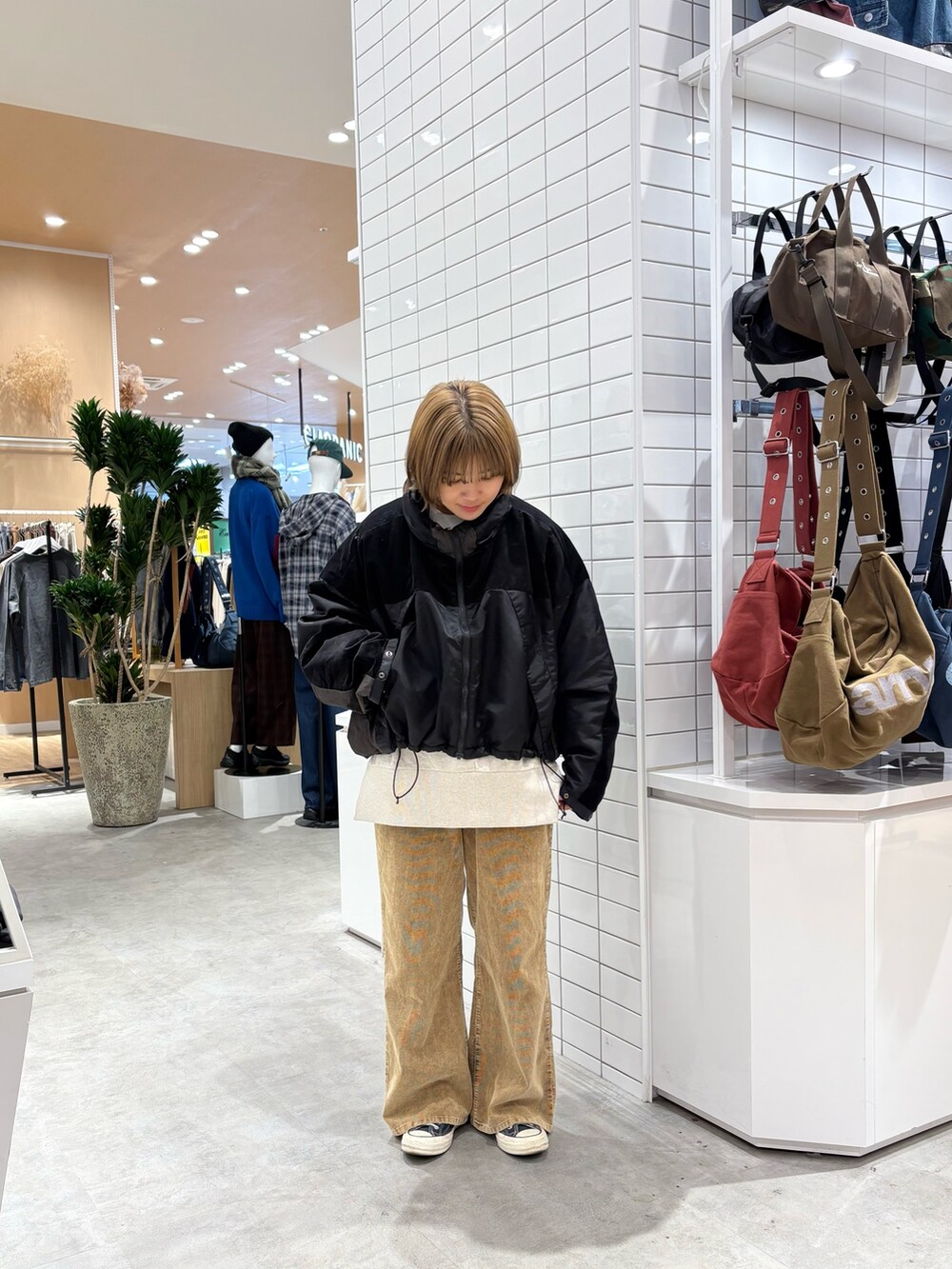 ブラック系のダウンジャケット/コート、ホワイト系のスウェット、イエロー系のデニムパンツを着用したレディースの秋コーディネートの2枚目の写真