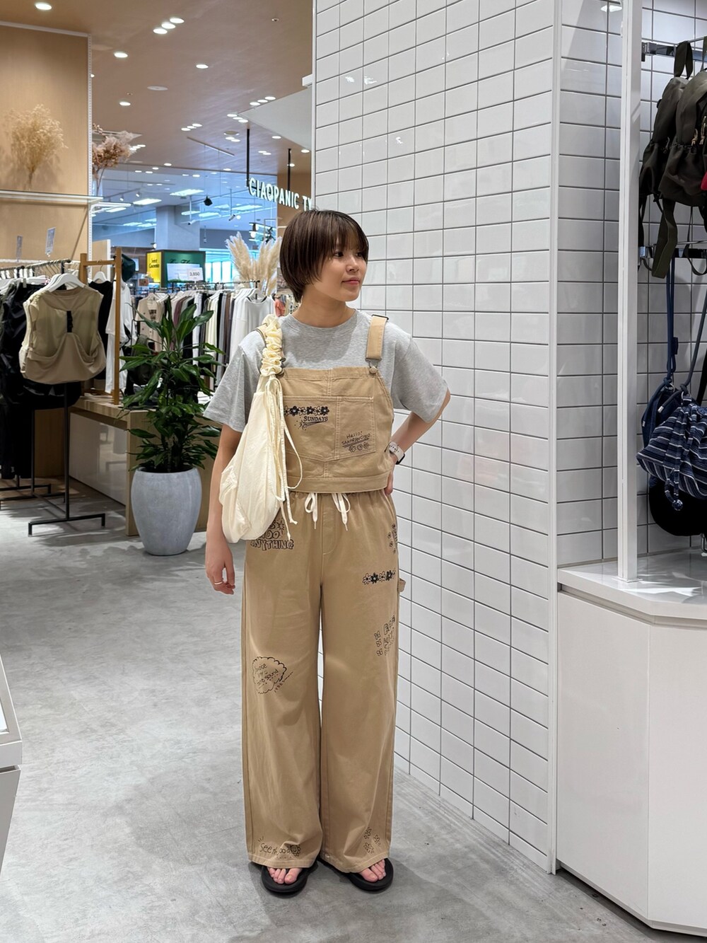 ベージュ系のサロペット/オーバーオール、ホワイト系のTシャツ/カットソー、ホワイト系のトートバッグを着用したレディースの夏コーディネートの3枚目の写真