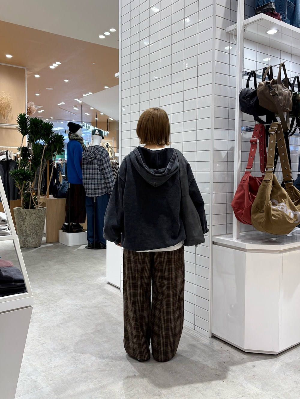 ブラック系のパーカー、ブラウン系のその他パンツ、グレー系のトートバッグを着用したレディースの秋コーディネートの5枚目の写真