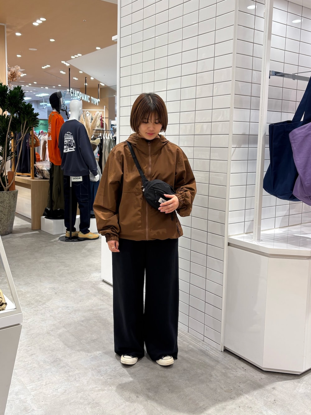 ブラック系のボディバッグ/ウエストポーチ、ブラウン系のマウンテンパーカー、ブラック系のスウェットパンツを着用したレディースの秋コーディネートの3枚目の写真