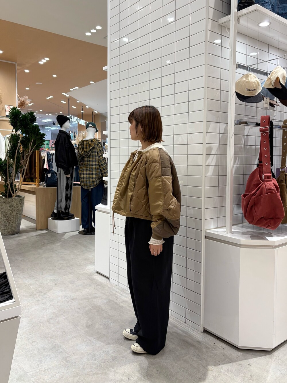 ブラック系のデニムパンツ、イエロー系のブルゾン、ホワイト系のTシャツ/カットソーを着用したレディースの秋コーディネートの3枚目の写真