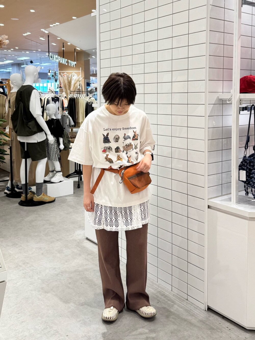 ホワイト系のTシャツ/カットソー、オレンジ系のボディバッグ/ウエストポーチ、ホワイト系のキャミソールを着用したレディースの春コーディネートの3枚目の写真