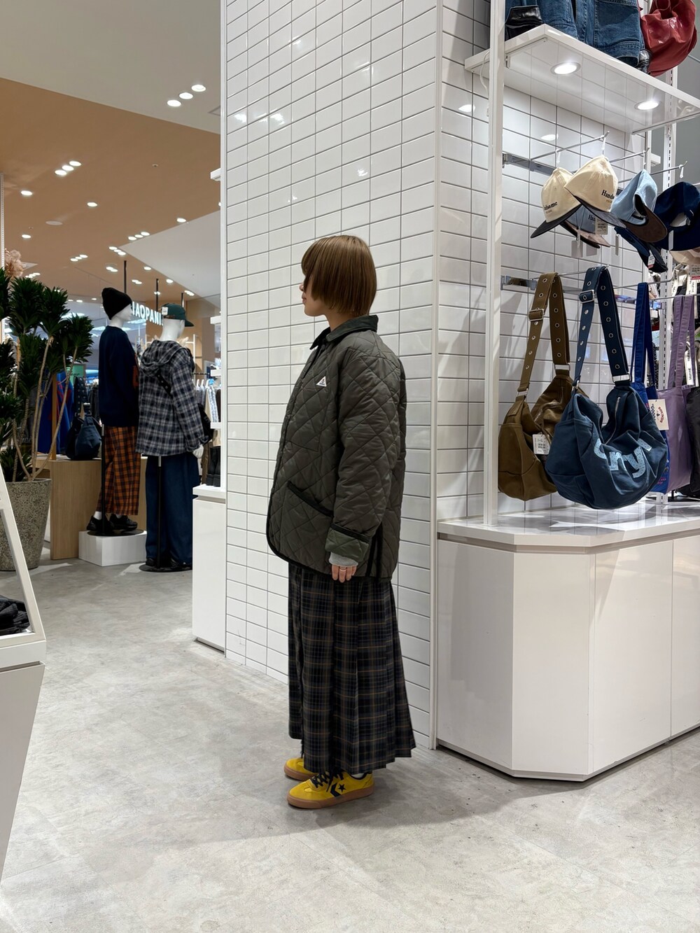 グリーン系のブルゾン、グレー系のスウェット、グレー系のスカートを着用したレディースの秋コーディネートの4枚目の写真