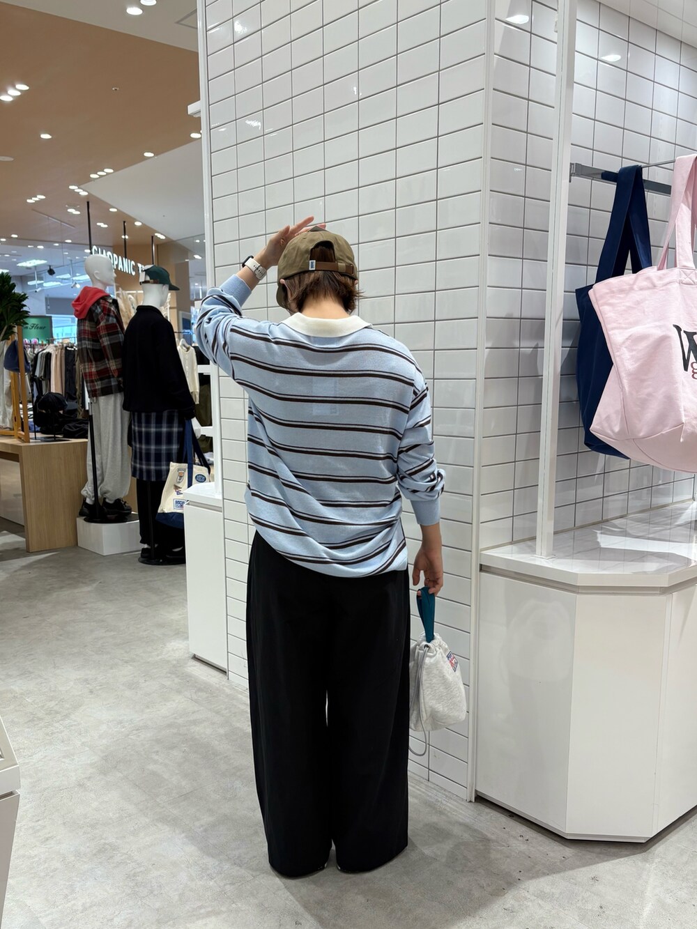 ブルー系のニット/セーター、ブラック系のデニムパンツ、グレー系のハンドバッグを着用したレディースの秋コーディネートの5枚目の写真