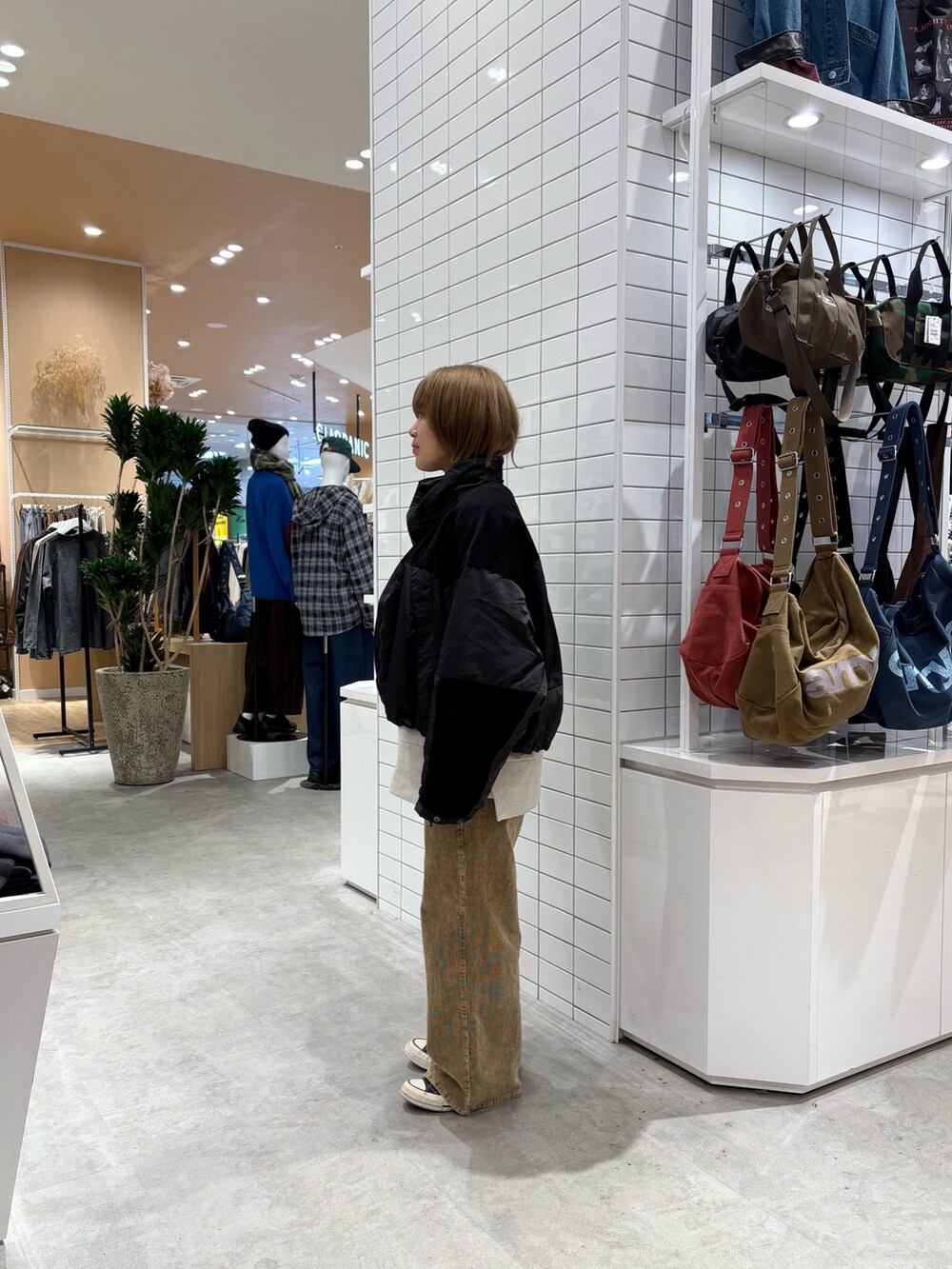 ブラック系のダウンジャケット/コート、ホワイト系のスウェット、イエロー系のデニムパンツを着用したレディースの秋コーディネートの4枚目の写真