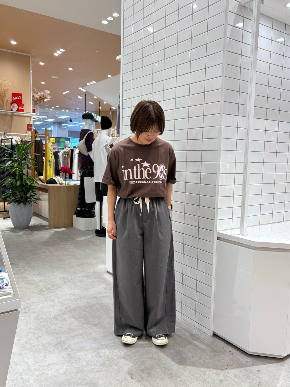グレー系のデニムパンツ、ブラウン系のTシャツ/カットソーを着用したレディースの秋コーディネートの2枚目の写真