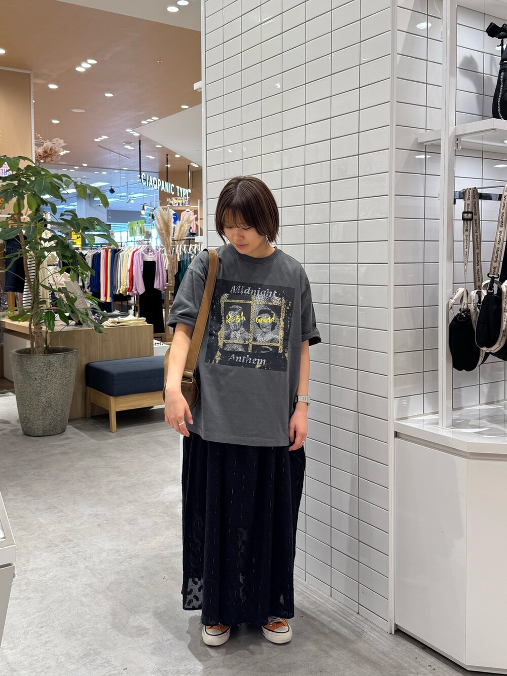 ブラック系のTシャツ/カットソー、ブラック系のワンピース、ブルー系のデニムパンツを着用したレディースの春コーディネートの3枚目の写真