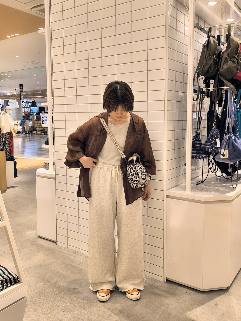 ホワイト系のスウェットパンツ、ホワイト系のショルダーバッグ、グレー系のタンクトップを着用したレディースの夏コーディネートの3枚目の写真