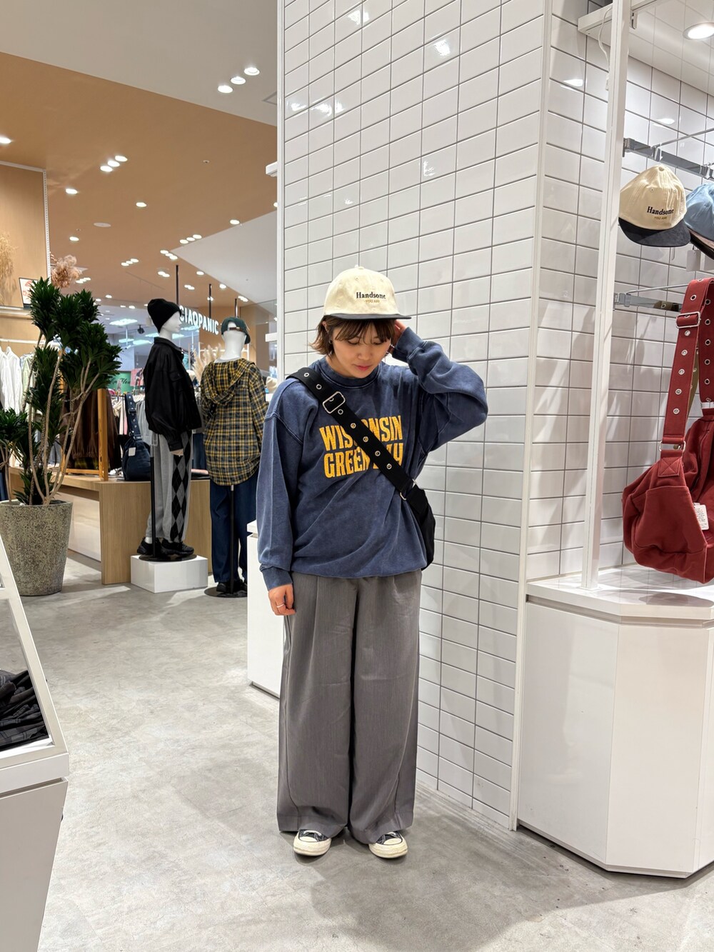 グレー系のデニムパンツ、ブルー系のスウェット、ブラック系のトートバッグを着用したレディースの秋コーディネートの2枚目の写真