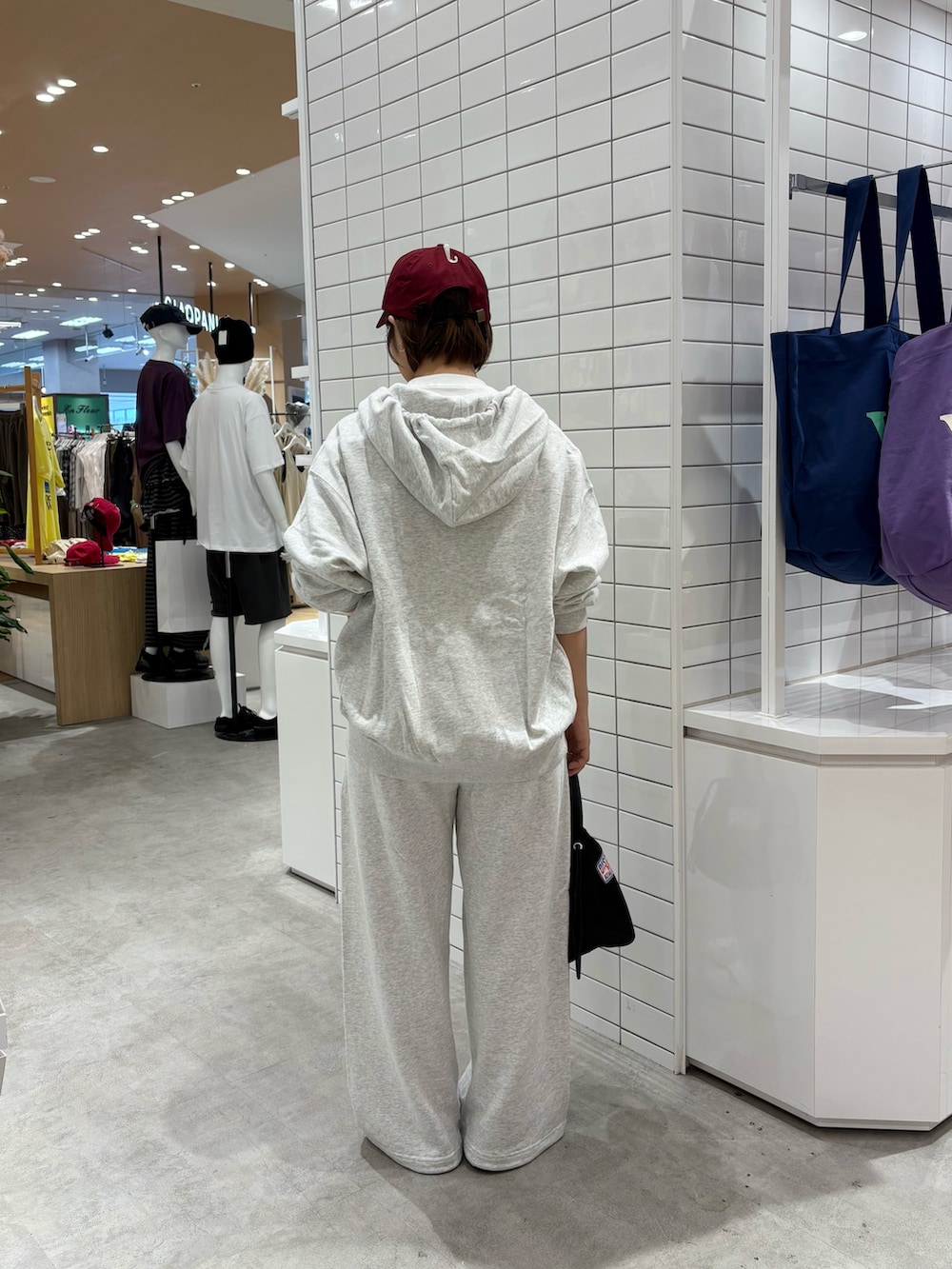 グレー系のパーカー、グレー系のスウェットパンツ、ブラック系のハンドバッグを着用したレディースの秋コーディネートの4枚目の写真