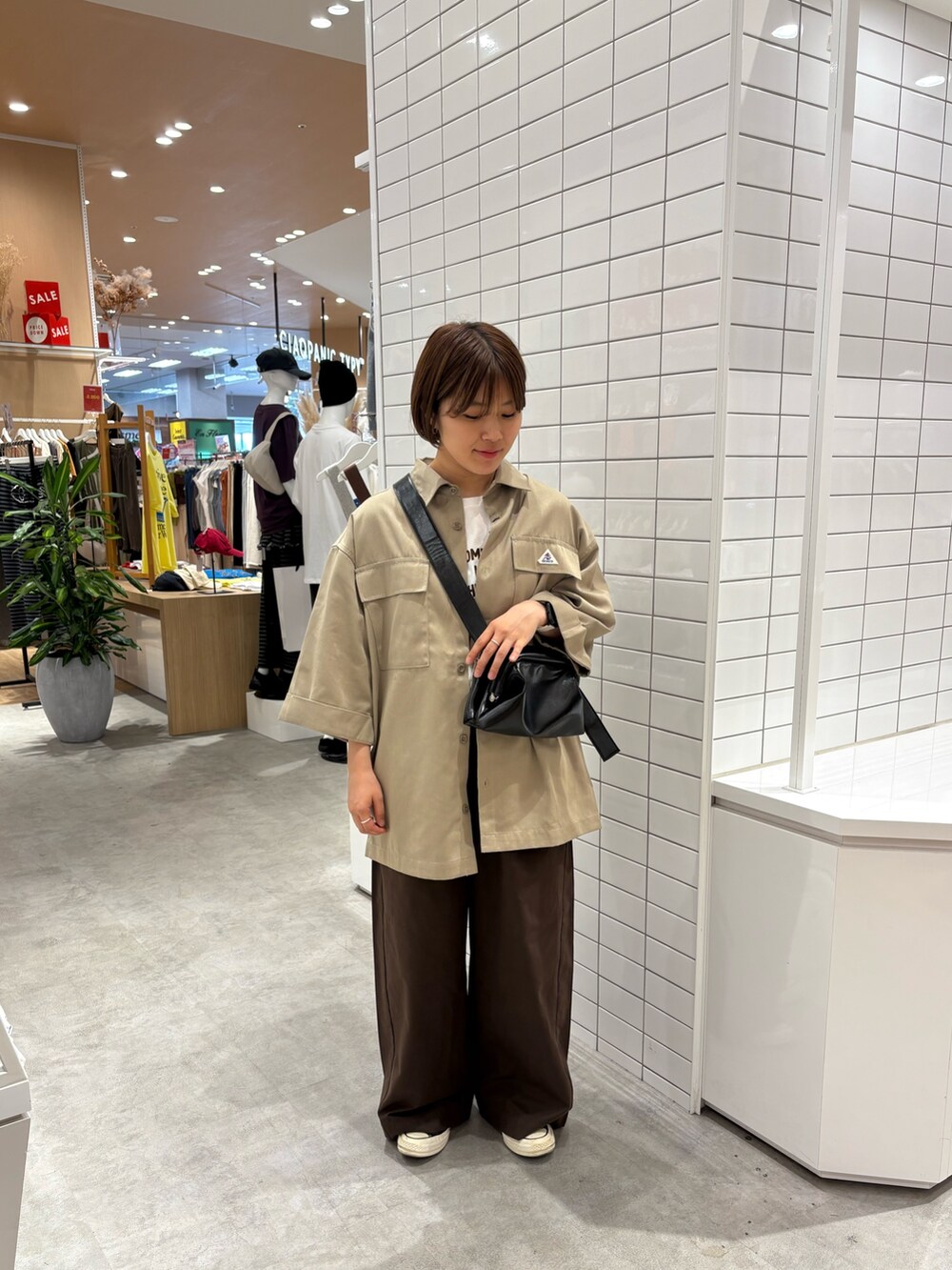 ブラウン系のデニムパンツ、ホワイト系のTシャツ/カットソー、ベージュ系のシャツ/ブラウスを着用したレディースの秋コーディネートの3枚目の写真