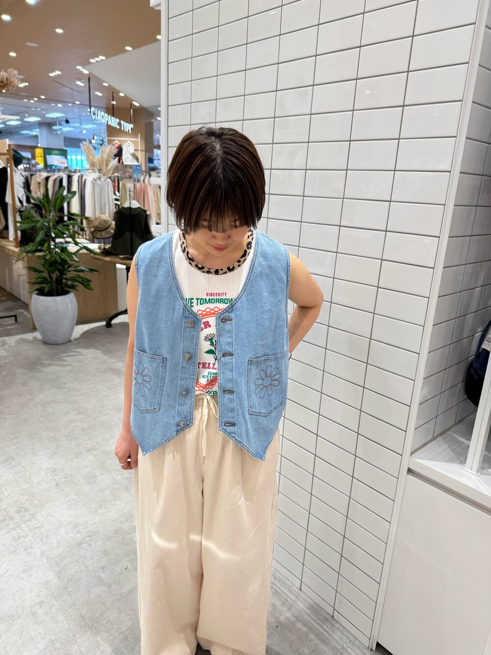 ホワイト系のデニムパンツ、シルバー系のサンダル、ホワイト系のタンクトップを着用したレディースの夏コーディネートの6枚目の写真