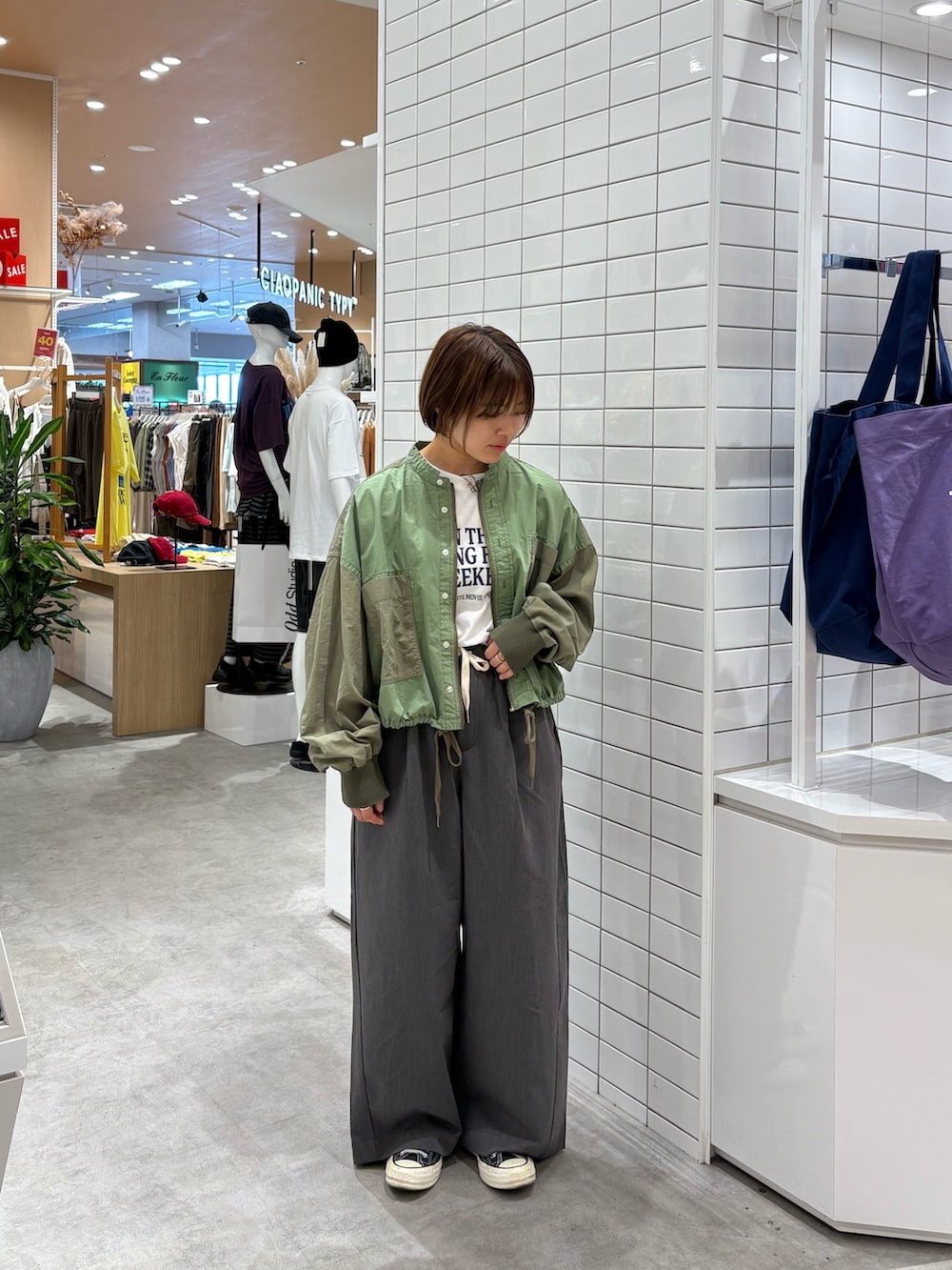 グレー系のデニムパンツ、ホワイト系のTシャツ/カットソー、グリーン系のブルゾンを着用したレディースの秋コーディネートの3枚目の写真