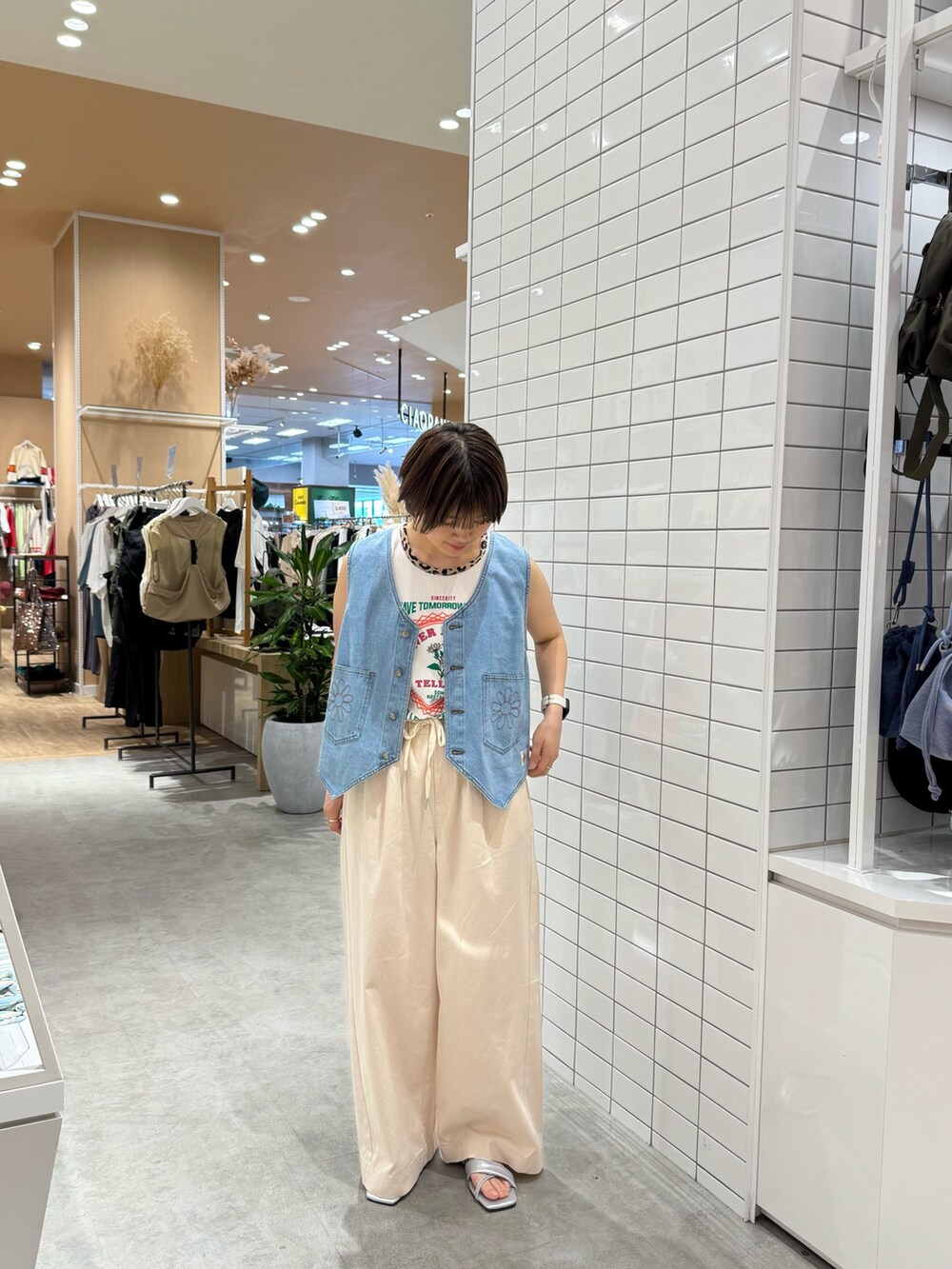ホワイト系のデニムパンツ、シルバー系のサンダル、ホワイト系のタンクトップを着用したレディースの夏コーディネートの3枚目の写真