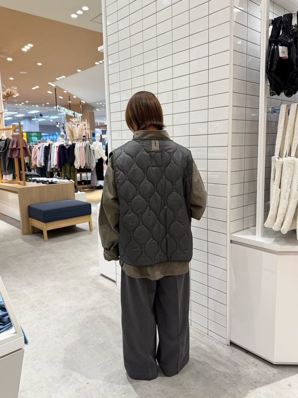 グリーン系のモッズコート、ホワイト系のTシャツ/カットソー、グレー系のパンツを着用したレディースの春コーディネートの2枚目の写真