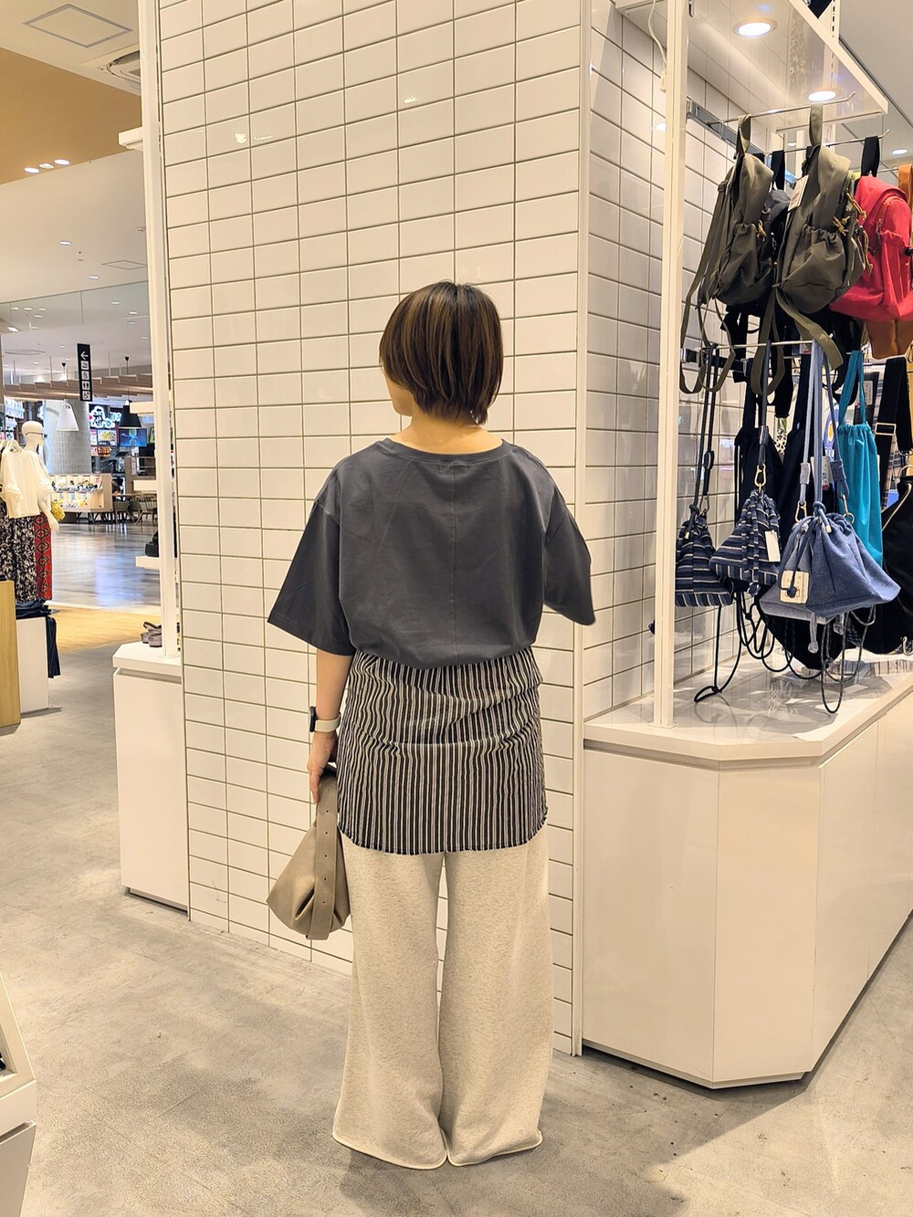 ホワイト系のスウェットパンツ、ベージュ系のショルダーバッグ、グレー系のTシャツ/カットソーを着用したレディースの夏コーディネートの4枚目の写真